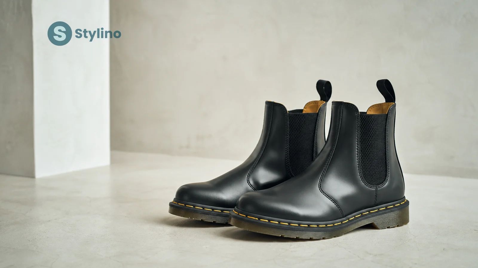 Dr. Martens 2976 Chelsea μπότα σε μαύρο Smooth δέρμα με κίτρινη ραφή και ελαστικά πλαϊνά πάνελ σε εκδοτικό teal φόντο