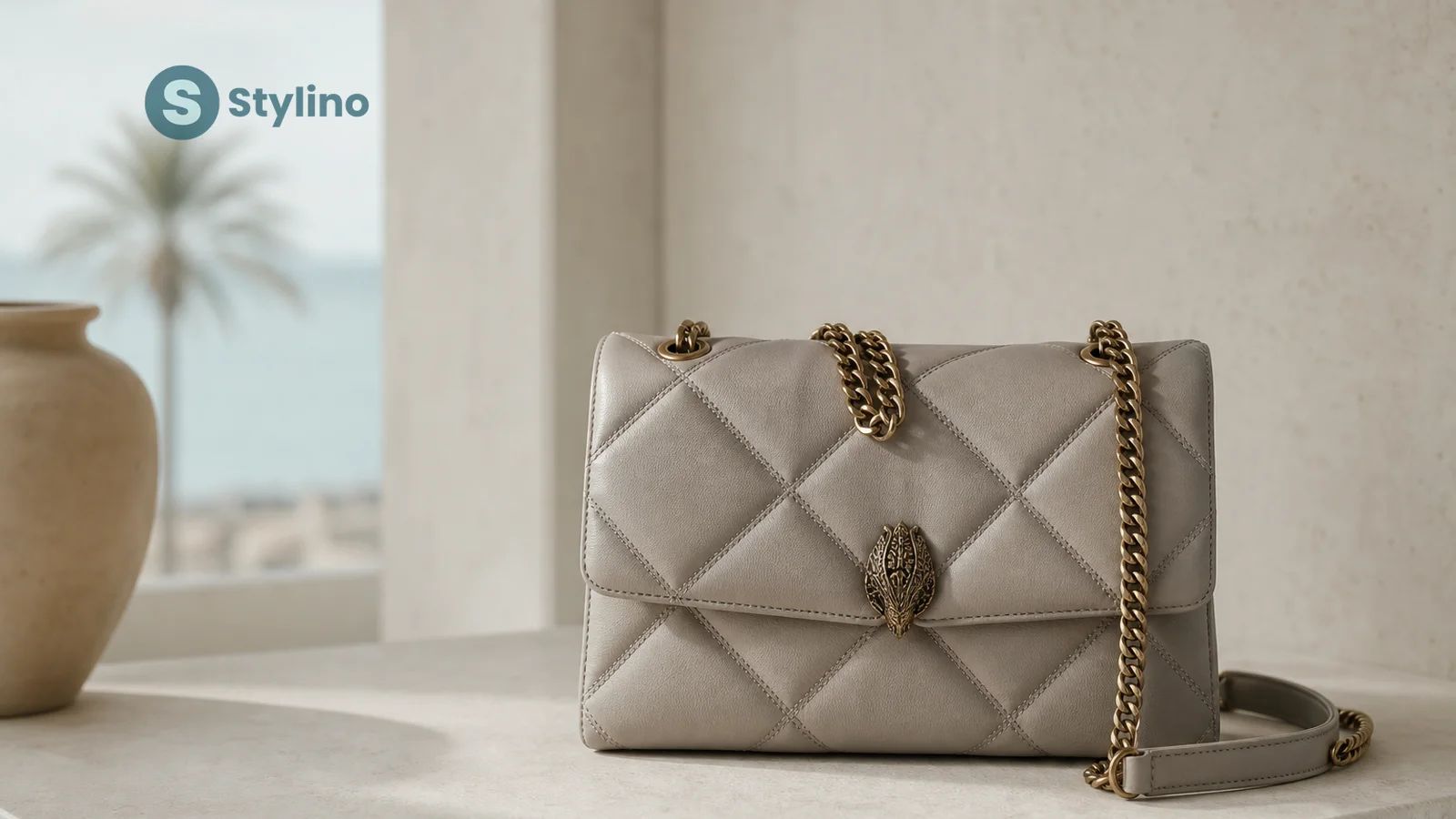 Kurt Geiger Kensington quilted leather bag with rainbow crystal strap displayed on marble surface