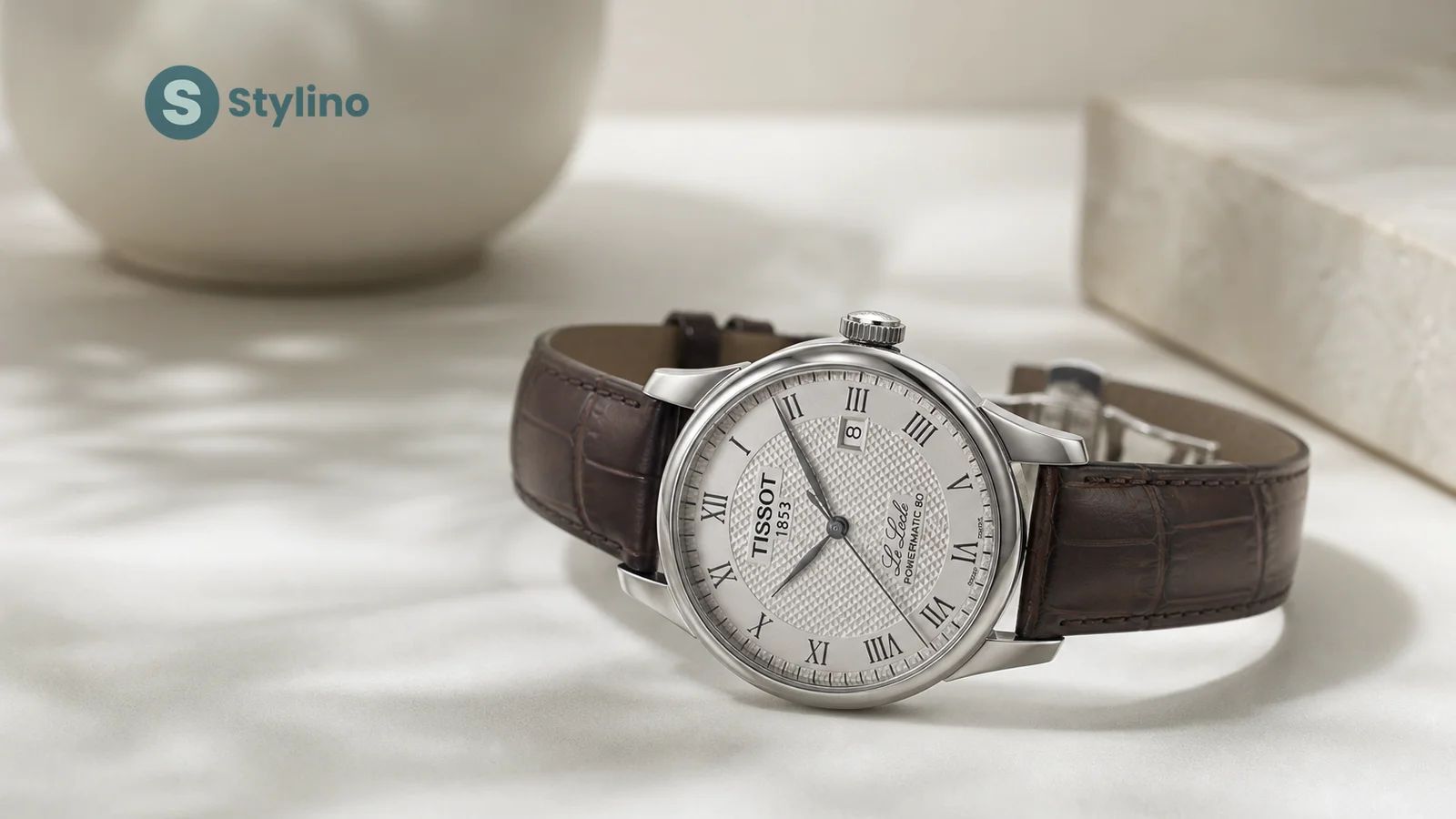 Οδηγός dress watches Tissot Le Locle — ελβετικό ρολόι guilloché καντράν σε teal editorial φόντο